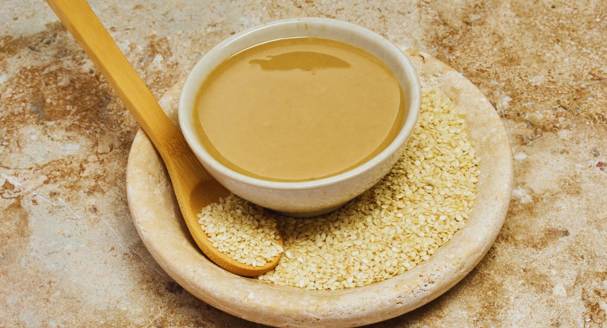 Bol de tahini crémeux entouré de graines de sésame