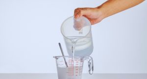 Eau versée dans un verre doseur gradué en millilitres