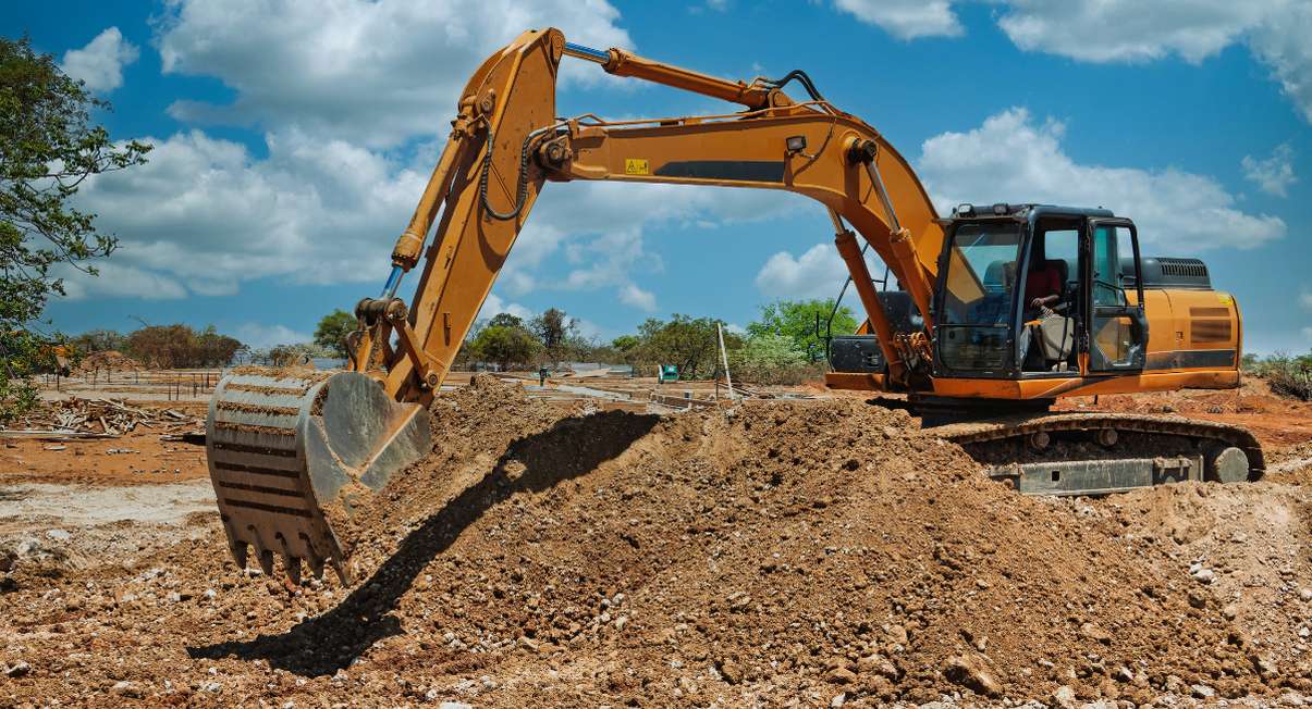Excavatrice creusant le sol meuble avant des travaux de terrassement