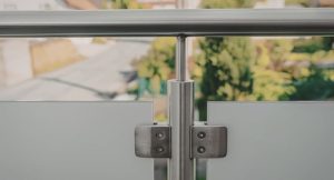 Garde-corps en verre maintenu par des pinces en acier inoxydable, installe en hauteur au-dessus de la rue