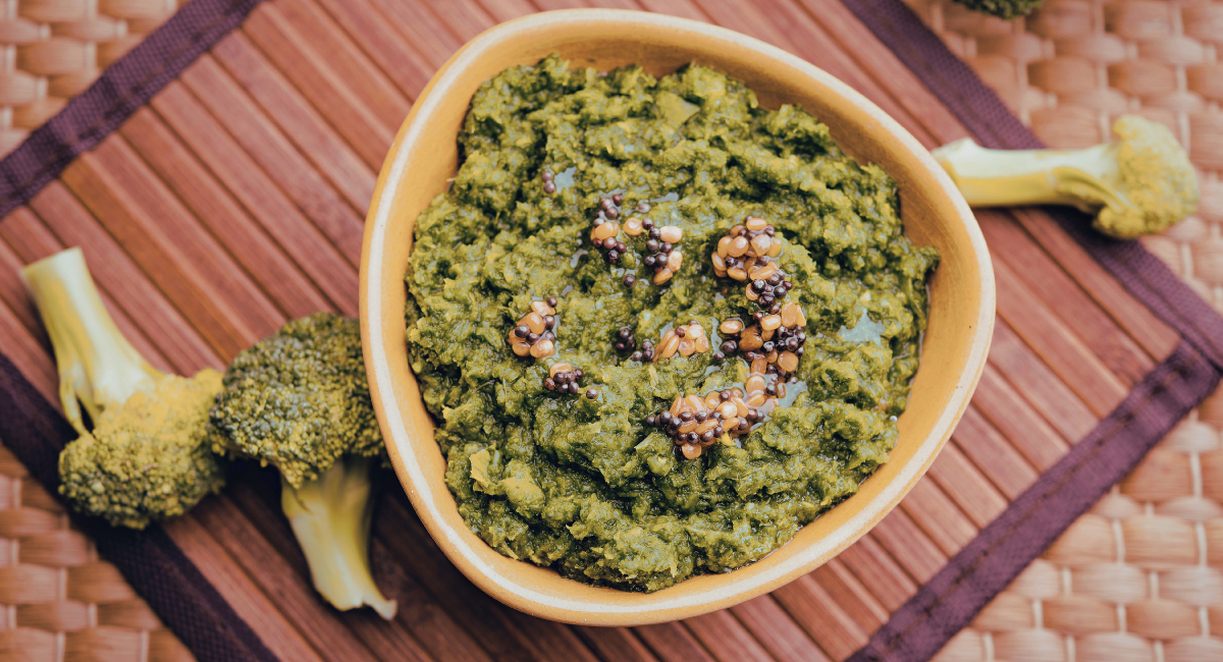Trempette verte au brocoli écrasé servie dans un bol avec des fleurons crus